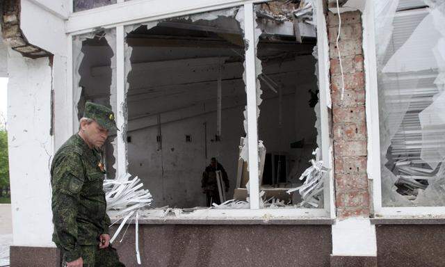 Eduard Basurin, deputy commander of the self-proclaimed Donetsk People's Republic, inspects a building, which according to locals was recently damaged by shelling, in Donetsk