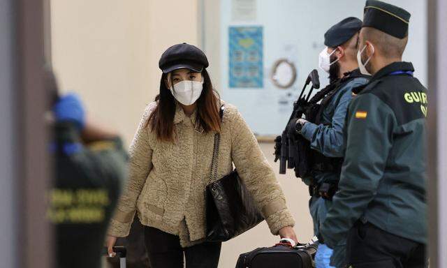 Eine Frau kommt mit einem Flieger aus Peking in Madrid an. Wie will man auf Einreisende aus China umgehen und damit auf die Coronavirus-Welle im Land reagieren? 