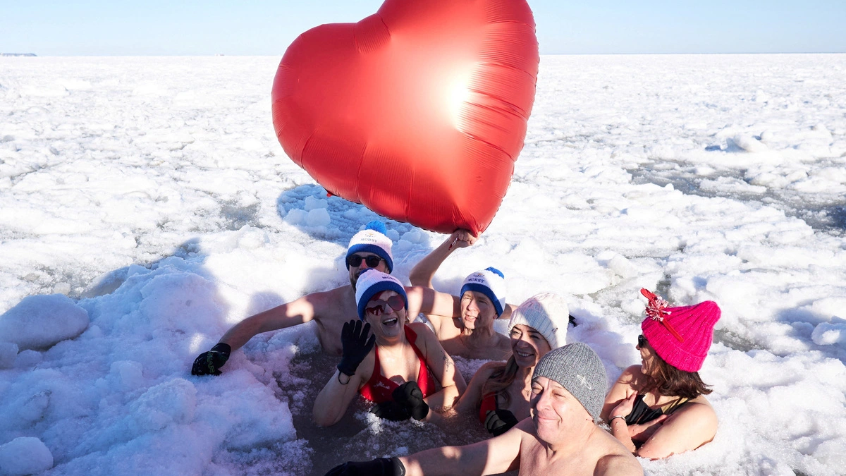 A person holds a heart-shaped balloon as people take a cold plunge in the icy water of the Baltic Sea during an event marking Valentine's Day, in Sopot, Poland, February 15, 2026. REUTERS/Bartosz Fatek     TPX IMAGES OF THE DAY