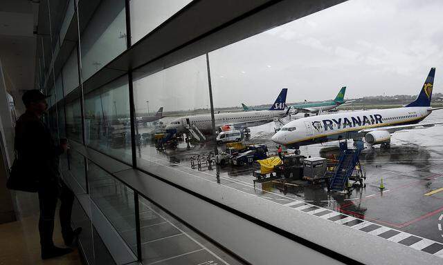 FILE PHOTO: A man looks out at a Ryanair plane in the Departures lounge at Dublin airport in Dublin