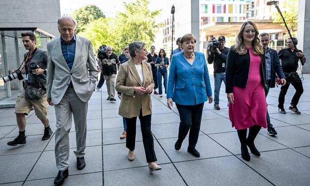 Lange nicht mehr gesehen: Die deutsche Ex-Bundeskanzlerin Angela Merkel (Mitte) war in Berlin zu Gast bei einer Feier für Jürgen Trittin (li.)