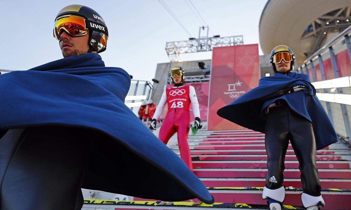Kein Batman in Pyeongchang, sondern Skispringern, die sich auf der Schanze warm halten.