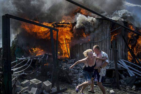 Für das russische Medienunternehmen "Rossiya Segodnya", das unter anderem die "Sputnik"-Nachrichtenportale betreibt, arbeitet der Fotograf Valery Melnikov. Dieses Foto gehört zur Bilderserie "Black Days Of Ukraine". Es zeigt Menschen, die nach einem Luftangriff aus ihrem Haus im Bezirk Stanytschno-Luhanske in der Ostukraine flüchten. 
