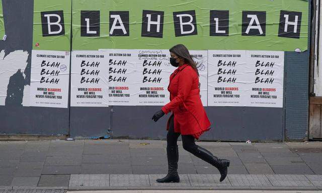 Frau vor Protestplakat in Glasgow