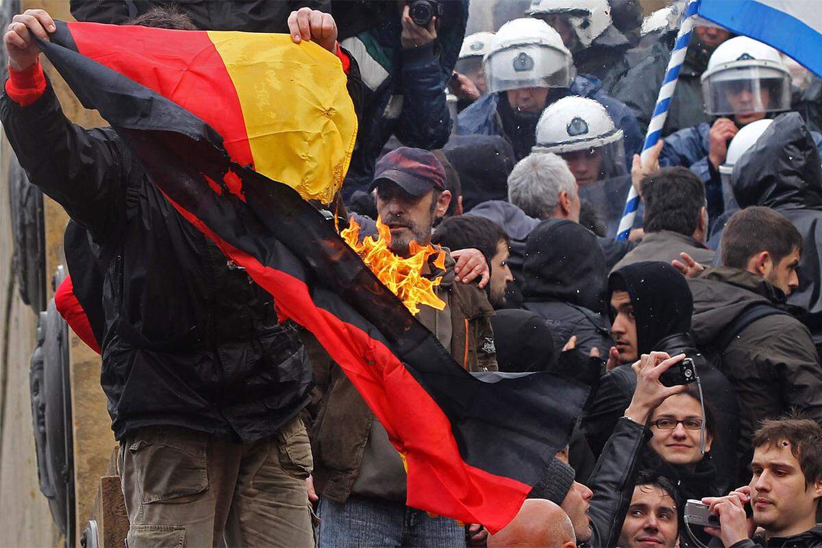 Bei Protesten gegen das Sparpaket hat eine Gruppe nationalistischer Demonstranten am Dienstag eine deutsche Flagge vor dem Parlament in Athen verbrannt.