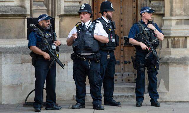 180815 LONDON Aug 15 2018 Armed policemen stand guard outside the Houses of Parliament i