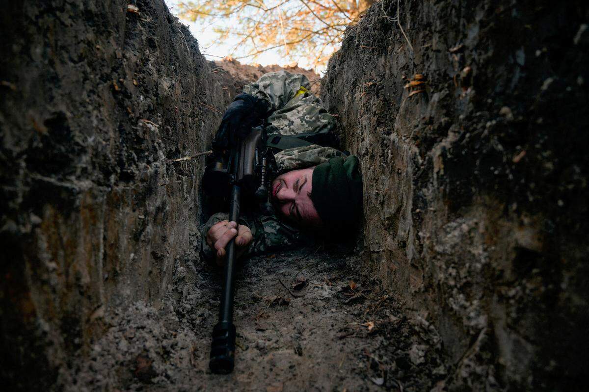 Schutz suchen: Ein ukrainischer Soldat versteckt sich in einem Graben vor einem Luftangriff.