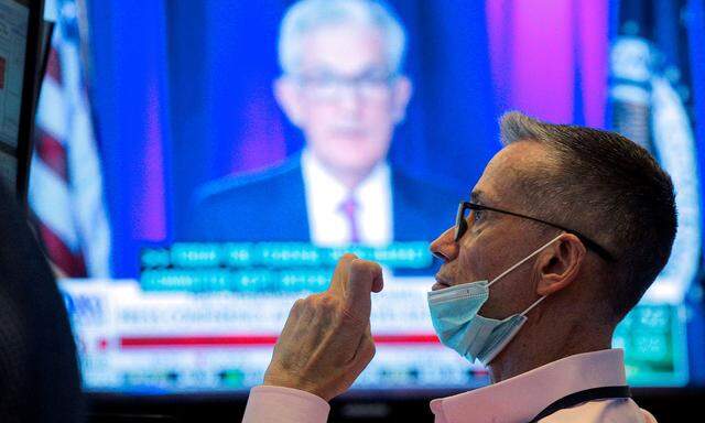 FILE PHOTO: A screen displays a statement by Federal Reserve Chair Jerome Powell following the U.S. Federal Reserve´s announcement as a trader works on the trading floor of the NYSE in New York