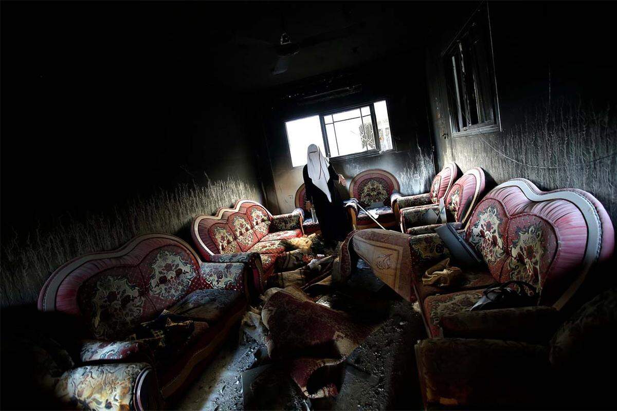 Eine Palästinensische Frau sieht sich ihr bei israelischen Angriffen zerstörtes Haus in Gaza an.