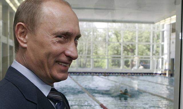 Russian President Putin smiles as he visits a swimming pool at Kurkino, one of huge sites on the northern fringes of Moscow