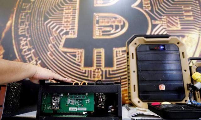 FILE PHOTO: A cryptocurrency mining computer is seen in front of bitcoin logo during the annual Computex computer exhibition in Taipei
