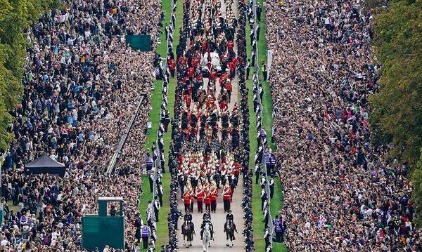 Tausende Menschen hatten sich zu beiden Seiten der als Long Walk bekannten Allee versammelt, um der Queen die letzte Ehre zu erweisen. Einige warfen Blumen, als das Auto mit dem in die royale Standarte gehüllten Sarg an ihnen vorbeifuhr.