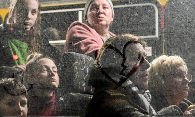 Menschen, die aus Mariupol und Melitopol geflohen sind, warten in einem Bus an einer Sammelstelle in Saporischschja. Für Freitag wurden sieben Fluchtkorridore aus umkämpften Städten in der Ukraine angekündigt.