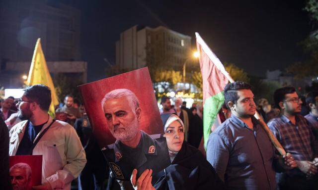 In Teheran organisierte das Regime Freudenfeiern nach dem Überfall der Hamas auf Israel. Eine Frau hält ein Porträt des früheren Al-Quds-Kommandanten Soleimani hoch.