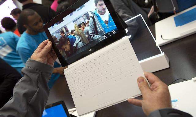 Sales staff demonstrate the Microsoft Surface during the opening of Microsoft's retail store in New York's Times Square