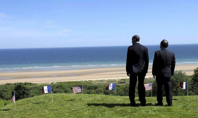 U.S. President Obama and French President Hollande look out over Omaha Beach during D-Day commemorations in Colleville-sur-Mer 