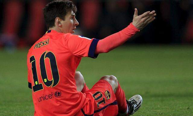 Barcelona/s Lionel Messi sits on the pitch as he reacts during their Spanish first division soccer match against Sevilla in Seville