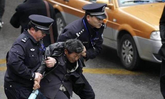 Police arrest a man in front of the Peace Cinema in downtown Shanghai, after calls for a Jasmine Rev