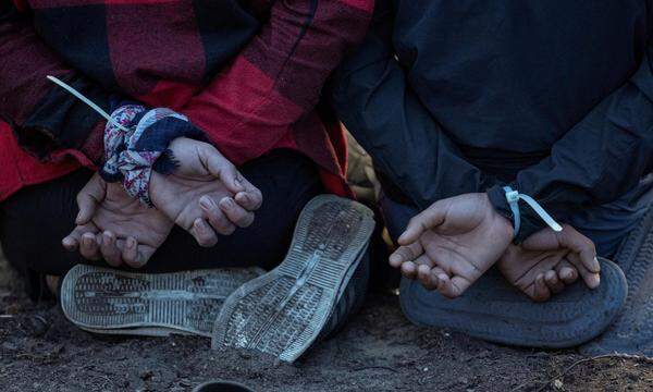 Flüchtlinge sitzen mit gefesselten Händen auf den Knien in der Nähe der Stadt Subotica in Serbien, nahe der serbisch-ungarischen Grenze. 