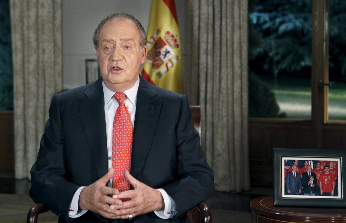 Ebenso wie Queen Elizabeth hält auch der spanische König Juan Carlos eine Ansprache an das Volk. Mit dabei auf dem Beistelltisch: Ein Bild des Königs und das spanische Nationalteam.