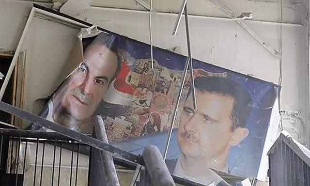 Ein zerstörtes Bild des syrischen Präsidenten Assad und seines Vaters