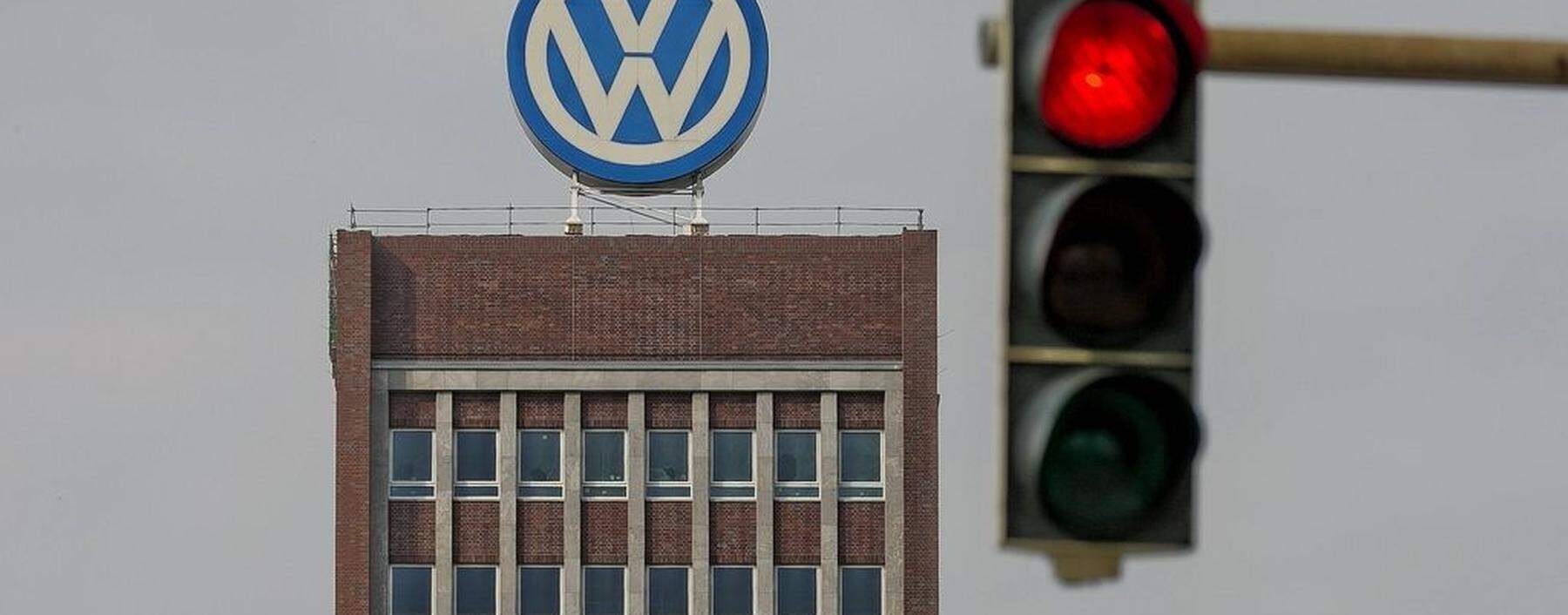 VW Emblem auf VW Verwaltungsgebaeude in Wolfsburg mit Roter Ampel gesehen am 09 04 2016