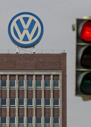 VW Emblem auf VW Verwaltungsgebaeude in Wolfsburg mit Roter Ampel gesehen am 09 04 2016