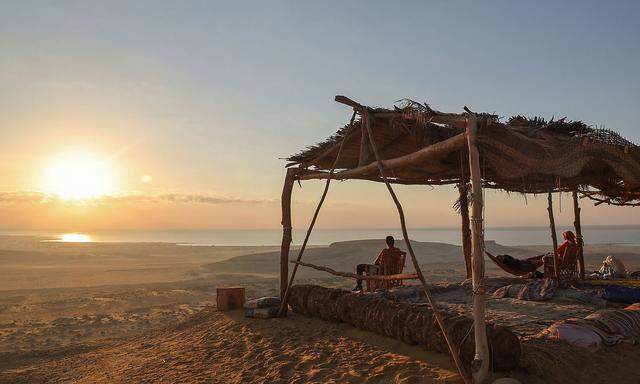 People watch sunrise on Qatrani camp next to Lake Qarun Protectorate in Fayoum
