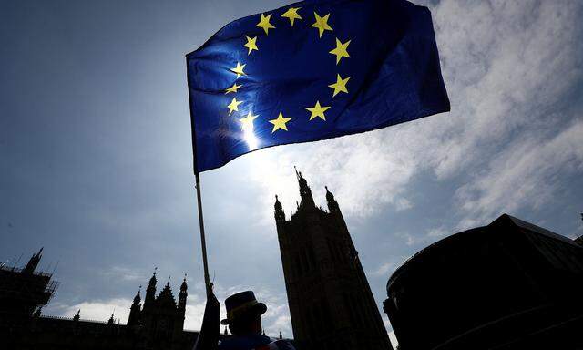 An anti-Brexit protester waves an EU flag opposite the Houses of Parliament in London