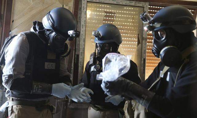 File photo of U.N. chemical weapons expert holding a plastic bag containing samples from one of the sites of an alleged chemical weapons attack in Ain Tarma