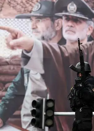 Ein Polizist in Teheran vor einem Plakat mit dem neuen Obersten Führer des Iran, Mojtaba Khamenei. 