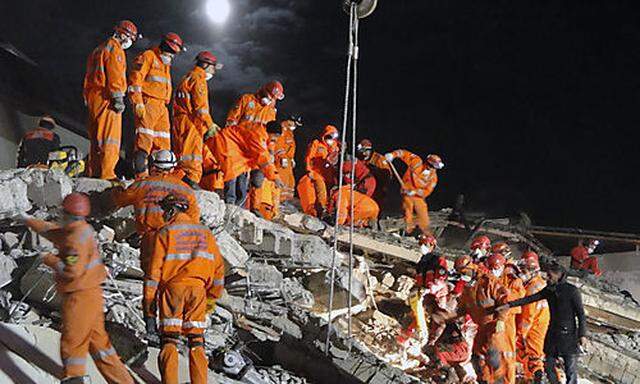 Turkish rescue workers search for survivors in the rubble of a collapsed hotel in Van, Turkey, Thursd