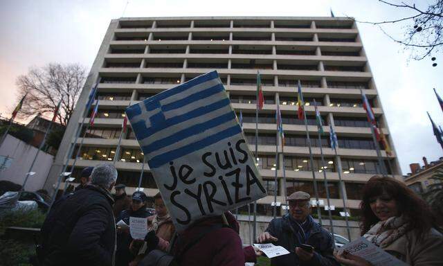 A woman holds a placard during a vigil to support the newly elected Greek government,