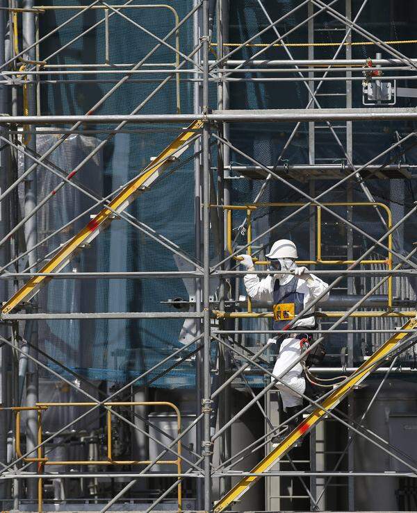 Die Atomruine ist nach Darstellung der Regierung und des Betreibers Tepco unter Kontrolle. Ein großes Problem bereiten jedoch die Unmengen Wasser, die weiterhin zur Kühlung der beschädigten Reaktoren benötigt werden. Bild: Ein Arbeiter auf dem Gerüst am AKW Fukushima Daiichi, aufgenommen am 6. März 2013.