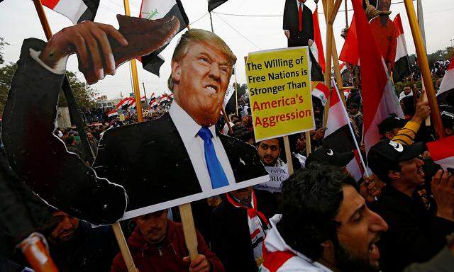 Supporters of Iraqi Shi'ite cleric Moqtada al-Sadr carry placards depicting U.S. President Donald Trump at a protest against what they say is U.S. presence and violations in Iraq, duri in Baghdad