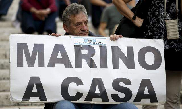 A man holds a banner reading ´Marino go home´ during a protest against Rome Mayor Marino in front of Rome´s city hall, ´Campidoglio´