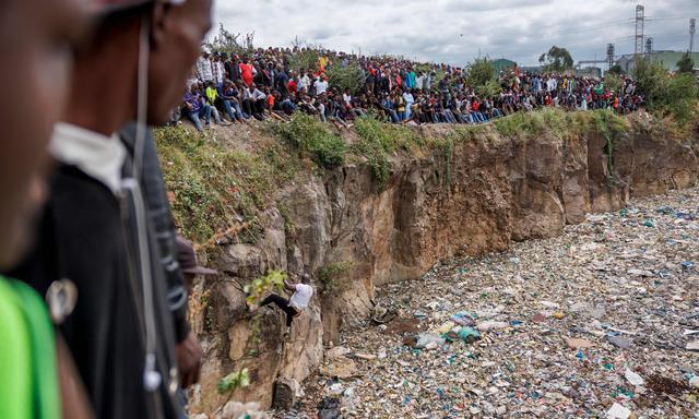 Menschen stehen am Rande einer Mülldeponie im Mukuru-Slum in Nairobi, wo am Wochenende Frauenleichen gefunden wurden. 