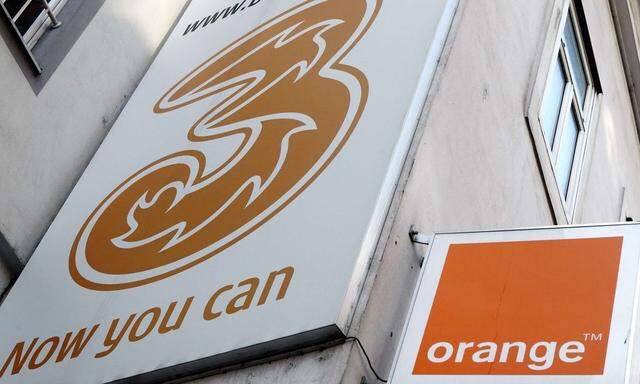 The logos of 'Orange' and '3' are pictured outside a telecommunications store in Vienna