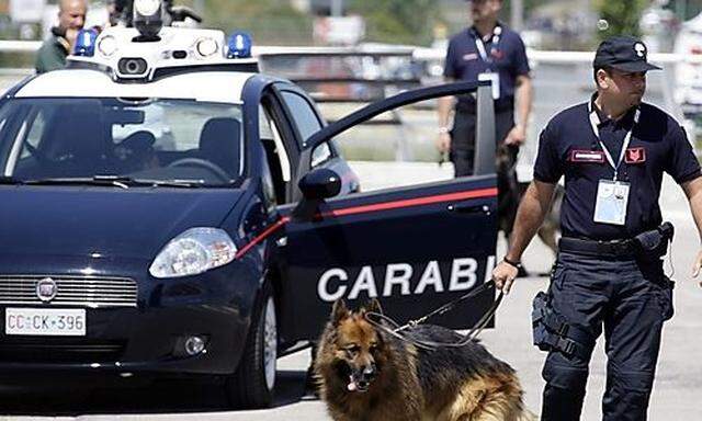 Italian paramilitary police officer searches for explosives with a dog at the accreditation center in