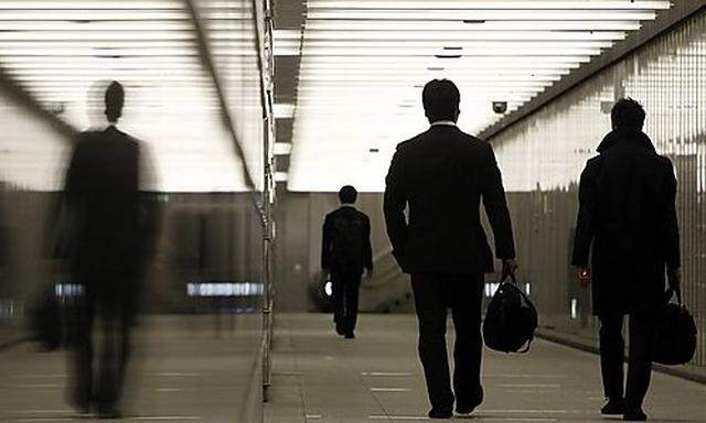 Businessmen walk through a business complex in Tokyo