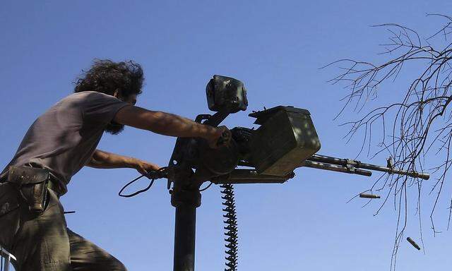 Free Syrian Army fighter fires weapon during what FSA said were clashes with forces loyal to President al-Assad in Idlib