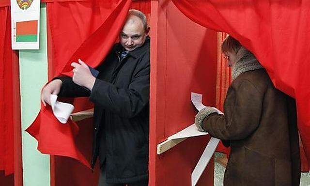 People fill in their ballots in voting booths at a polling station during presidential elections in M