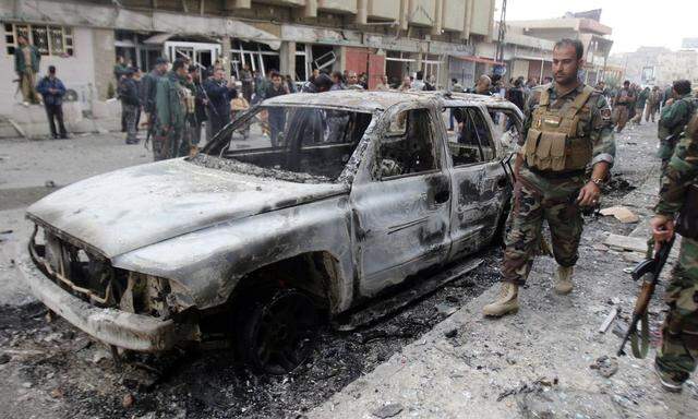 Members of the Kurdish security forces inspect the site of bomb attack in Kirkuk