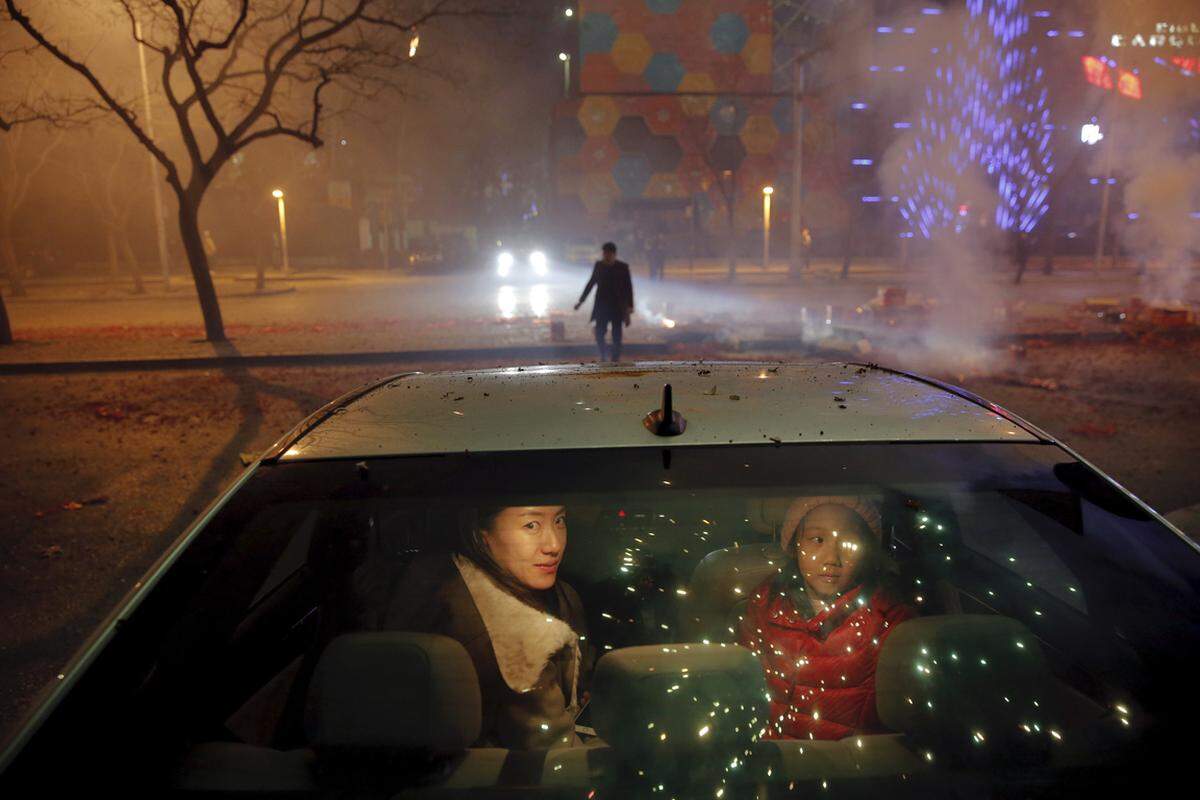 7. Februar. Kein anderes Land verschießt zu Neujahr so viele Feuerwerkskörper wie China. Eine Frau und ihre Tochter beobachteten das Spektakel zu Beginn des Neuen Jahres, des Jahres des Affen, von ihrem Auto in Peking aus.