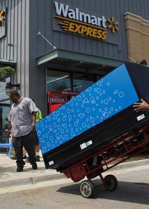 Workers move a vending machine into position outside a new Walmart Express store in Chicago