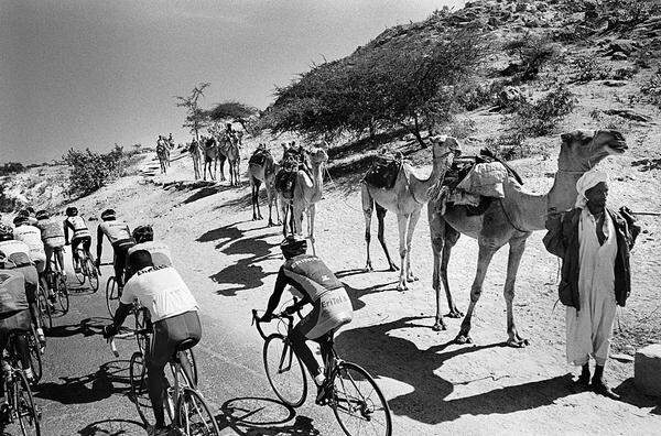 Chris Keulen, Niederlande, Panos für Geo  Radtour durch Afrika: Das Nationalteam Eritreas passiert auf der Straße zwischen Barentu und Keren eine Kamel-Karawane.