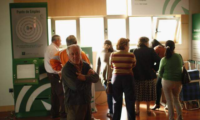 People wait inside a government-run employment office in Campillos, near Malaga