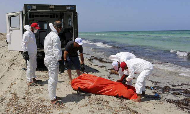 Libyan Red Crescent workers move the body of a dead migrant that was recovered by the Libyan coastguard after a boat sank off the coastal town of Zuwara