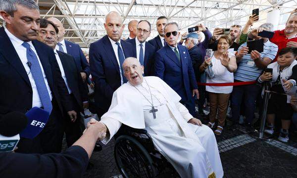 Papst Franziskus wird in einem Rollstuhl aus dem Krankenhaus in Rom geschoben.
