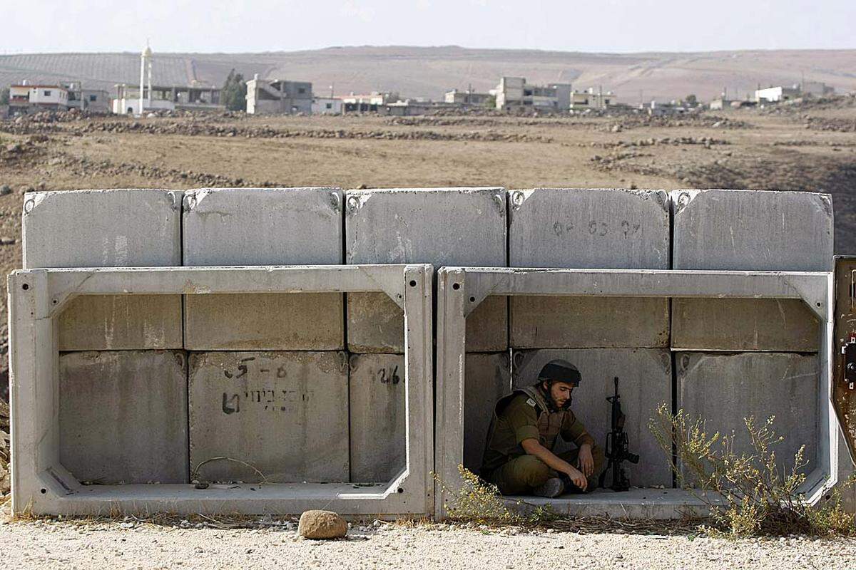 Ein israelischer Soldat sucht hinter Betonblöcken Schutz. Das Grenzdorf Ghajar soll aufgegeben werden, um die Spannungen mit dem Nachbarland Libanon abzubauen.